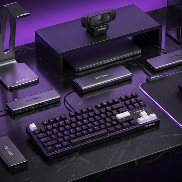 A clean, modern workspace featuring an OWTRLD ergonomic laptop stand, a sleek USB-C docking station, and a wireless mechanical keyboard on a minimalist desk